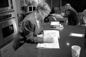 Sylvia Sabo sits at a table and does a puzzle. 